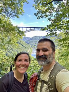couple standing in front of new river gorge bridge