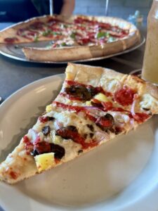 pizza on white plate with pineapple, mushrooms,