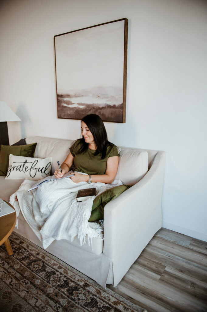 kathy sitting on the couch, journaling